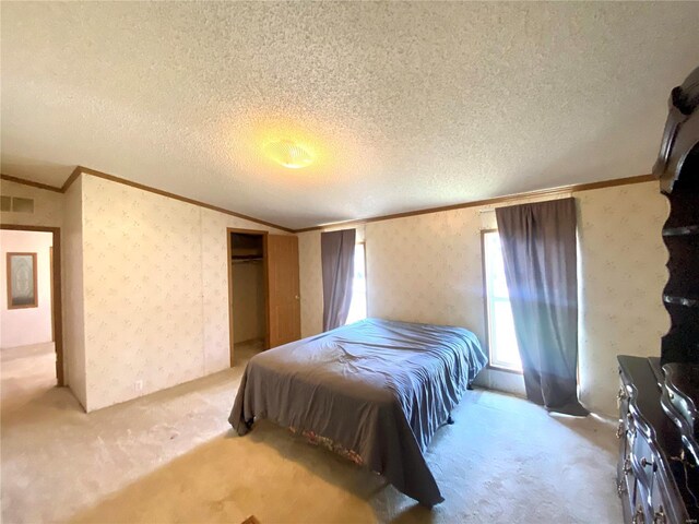 bedroom featuring wallpapered walls, a textured ceiling, visible vents, and crown molding