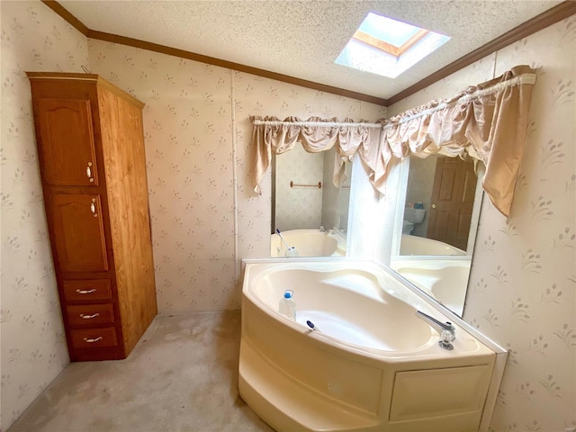 full bathroom with a textured ceiling, lofted ceiling with skylight, a bath, and wallpapered walls