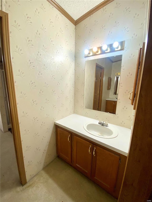 bathroom with wallpapered walls, a textured ceiling, and vanity