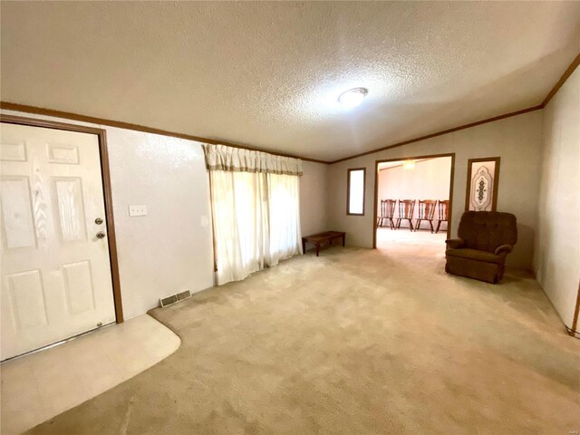 interior space featuring light carpet, visible vents, lofted ceiling, a textured ceiling, and crown molding