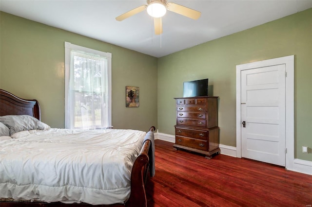 bedroom featuring dark wood-type flooring, a ceiling fan, and baseboards