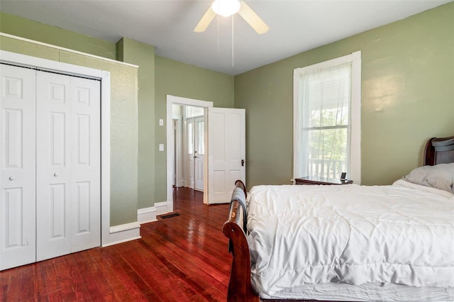 bedroom with a ceiling fan, dark wood-style flooring, a closet, and baseboards