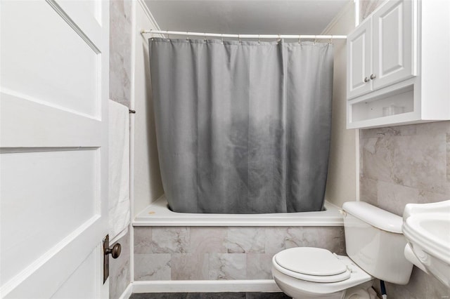 full bathroom with tiled shower / bath combo and toilet