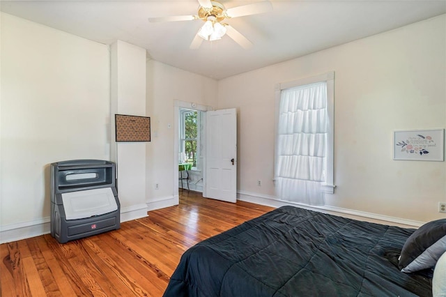 bedroom featuring wood finished floors, a ceiling fan, and baseboards