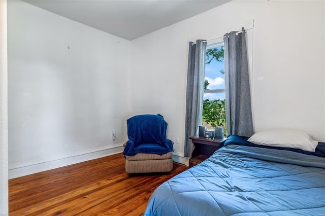 bedroom featuring baseboards and wood finished floors