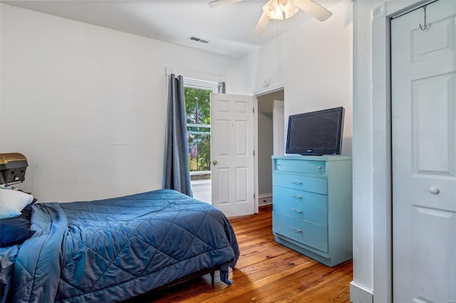 bedroom featuring wood finished floors, visible vents, and a ceiling fan