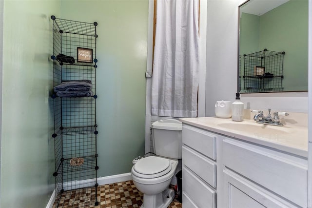 bathroom featuring vanity, toilet, and baseboards