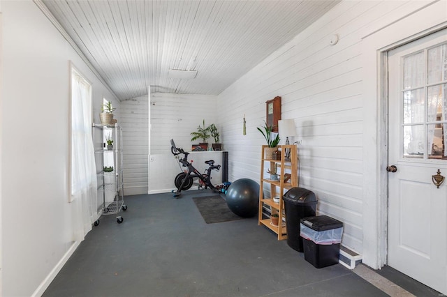 exercise room with lofted ceiling and baseboards