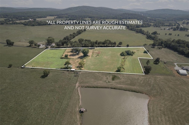 drone / aerial view with a water and mountain view and a rural view