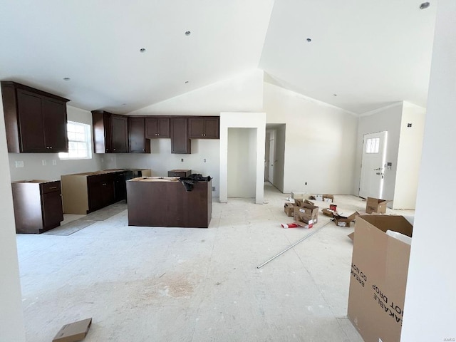 kitchen featuring lofted ceiling, a kitchen island, and dark brown cabinetry