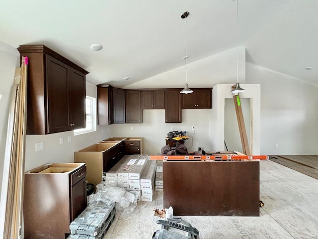 kitchen with lofted ceiling, dark brown cabinets, and pendant lighting