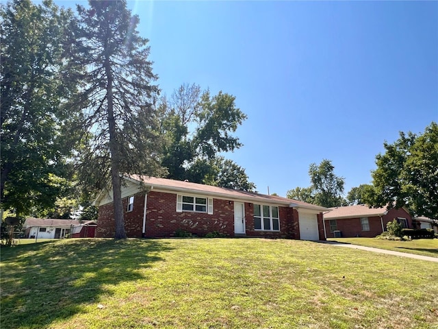 single story home featuring a garage, brick siding, driveway, and a front lawn