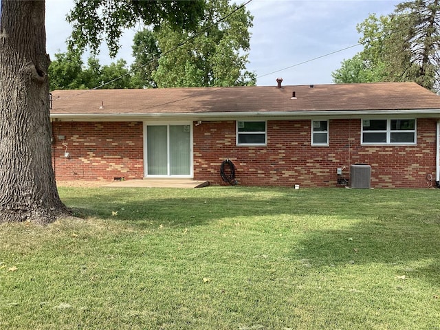 rear view of house featuring cooling unit and a yard