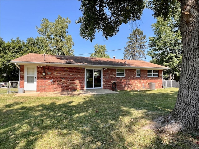 back of house featuring central AC unit, a patio area, and a yard