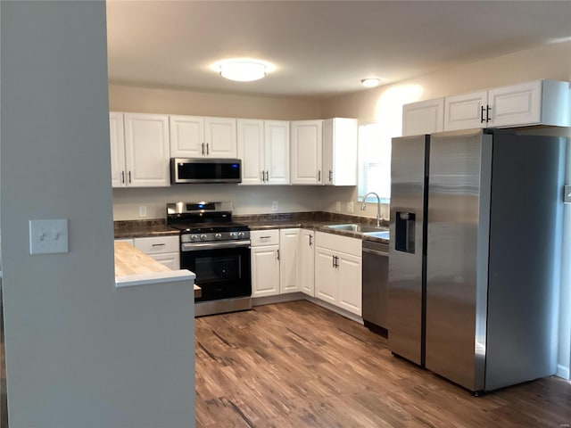 kitchen featuring white cabinetry, sink, dark wood-type flooring, and appliances with stainless steel finishes