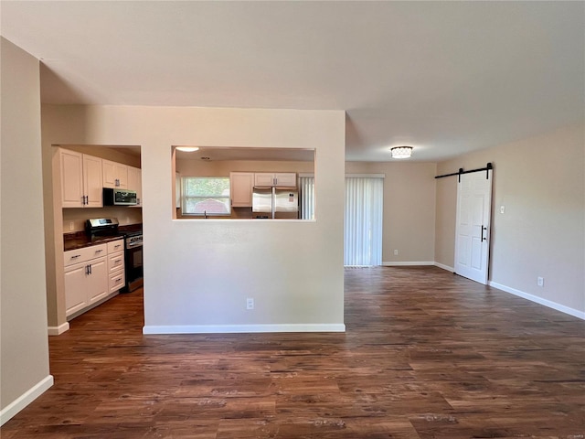 interior space featuring a barn door and dark hardwood / wood-style flooring