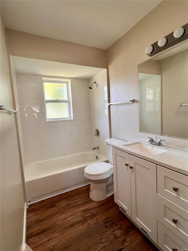 full bathroom with toilet, hardwood / wood-style floors, vanity, and tiled shower / bath