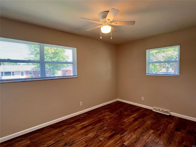 unfurnished room with plenty of natural light, dark hardwood / wood-style floors, and ceiling fan