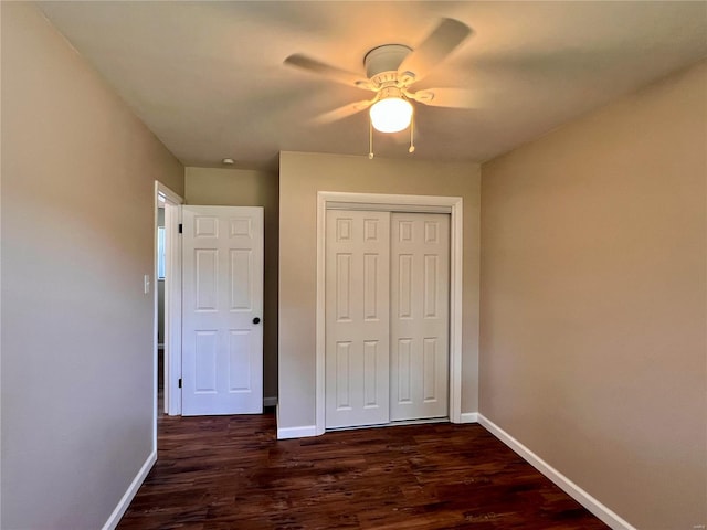 unfurnished bedroom with dark hardwood / wood-style flooring, a closet, and ceiling fan