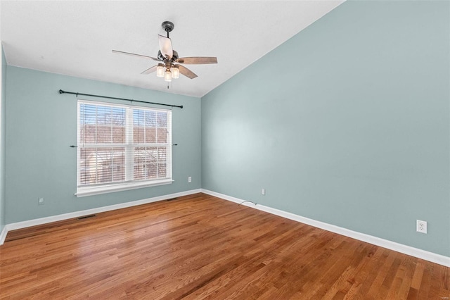 spare room with visible vents, ceiling fan, baseboards, and wood finished floors