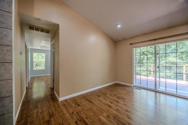 spare room featuring vaulted ceiling and hardwood / wood-style floors