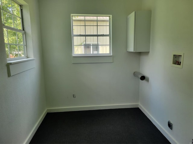 washroom featuring laundry area, washer hookup, dark colored carpet, and baseboards