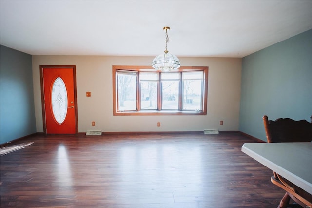 foyer entrance featuring dark hardwood / wood-style flooring and an inviting chandelier