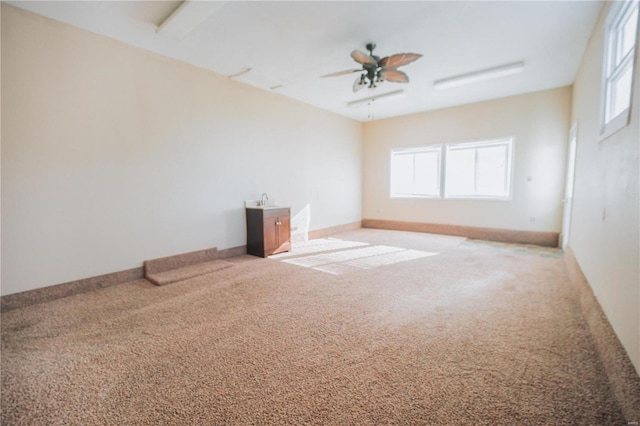 carpeted spare room with ceiling fan