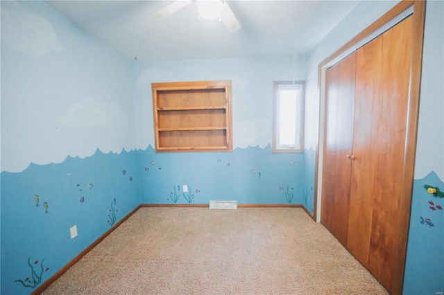 unfurnished bedroom featuring carpet, ceiling fan, and a closet