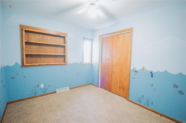 unfurnished bedroom featuring carpet flooring, a closet, and ceiling fan