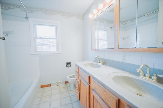 full bathroom featuring vanity, toilet, decorative backsplash, and tiled shower / bath