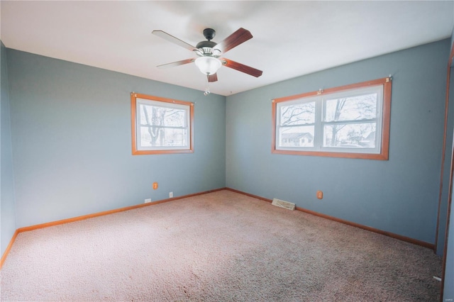 carpeted empty room with plenty of natural light and ceiling fan