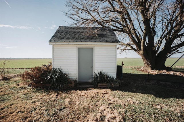 view of outdoor structure featuring a rural view and a yard