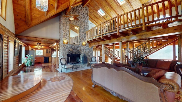 living room with wood-type flooring, high vaulted ceiling, beamed ceiling, and a skylight