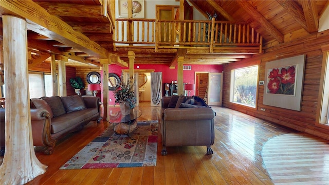 living room featuring wood ceiling, hardwood / wood-style flooring, beam ceiling, decorative columns, and high vaulted ceiling