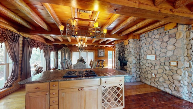 kitchen with a kitchen island, black gas stovetop, wooden ceiling, beam ceiling, and light hardwood / wood-style flooring