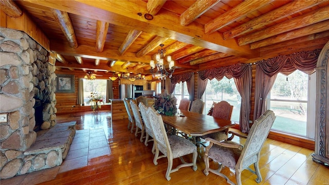 dining space with an inviting chandelier, beamed ceiling, wood ceiling, and light hardwood / wood-style floors