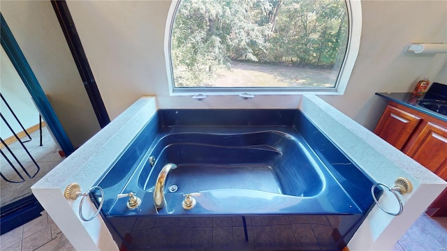 interior details featuring vanity, a bathtub, and tile patterned flooring