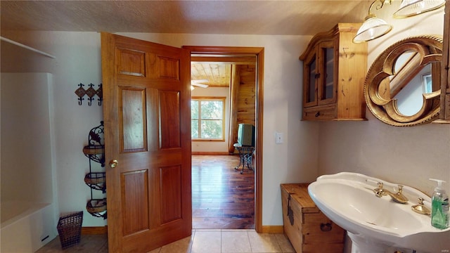 bathroom featuring shower / washtub combination, sink, and hardwood / wood-style floors