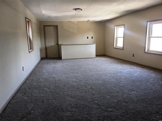 carpeted empty room featuring a textured ceiling