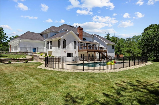 rear view of house featuring a yard and a fenced in pool