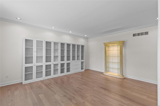 empty room featuring crown molding and wood-type flooring