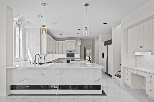 kitchen featuring decorative light fixtures, double oven, white cabinets, paneled built in fridge, and light tile patterned flooring