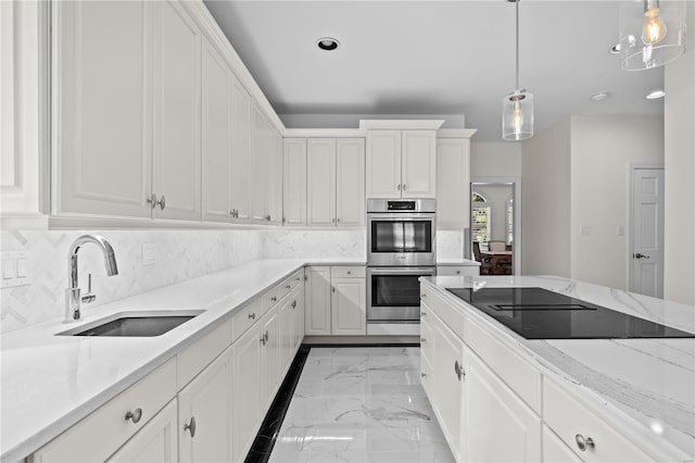 kitchen featuring backsplash, black electric cooktop, sink, double oven, and light tile patterned floors