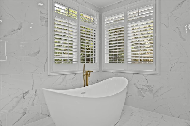 bathroom with tile walls, a washtub, and tile patterned floors