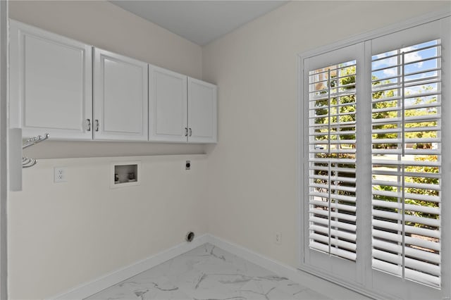 laundry area featuring electric dryer hookup, hookup for a washing machine, cabinets, and light tile patterned flooring