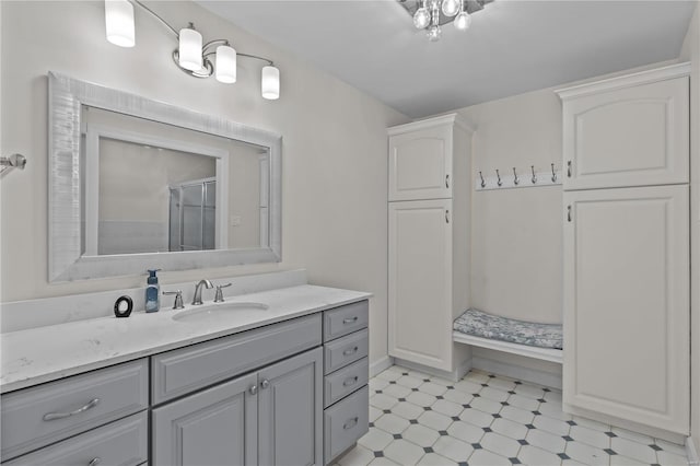 bathroom featuring tile patterned flooring, a shower with door, and vanity