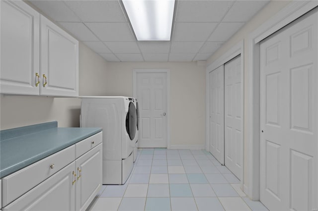 clothes washing area featuring light tile patterned floors, cabinets, and washer / dryer