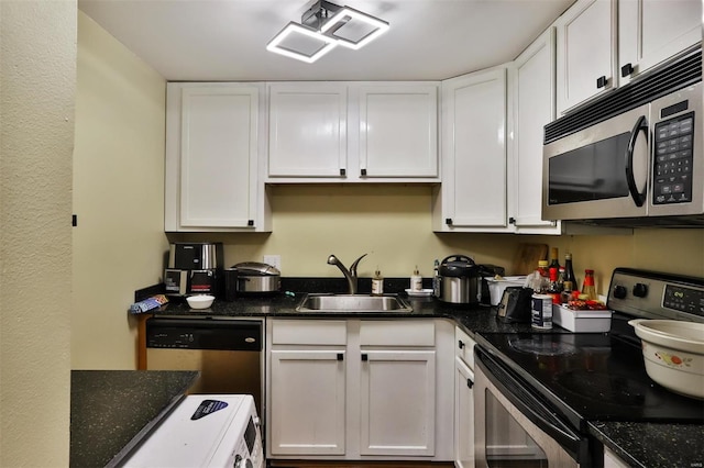 kitchen with sink, stainless steel appliances, white cabinets, and dark stone countertops