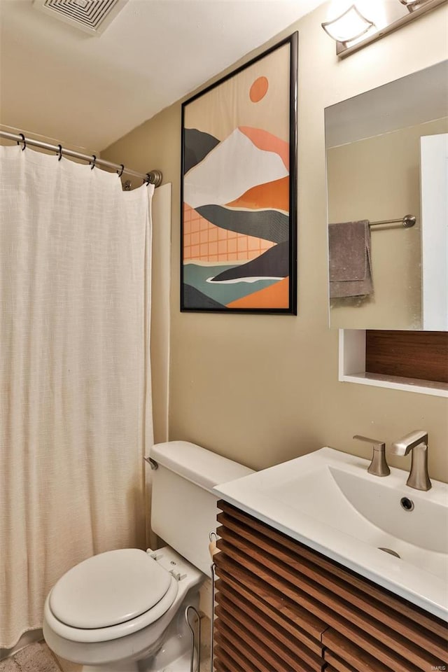 bathroom with curtained shower, vanity, and toilet